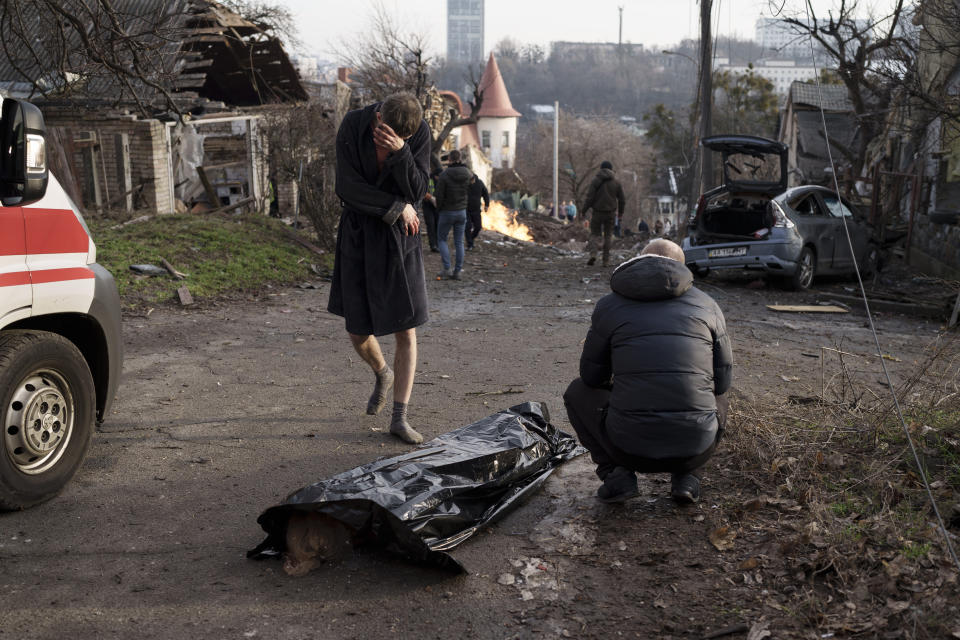 A man reacts next to the body of his wife, killed during a Russian attack in Kyiv, Ukraine, Saturday, Dec. 31, 2022. (AP Photo/Roman Hrytsyna)