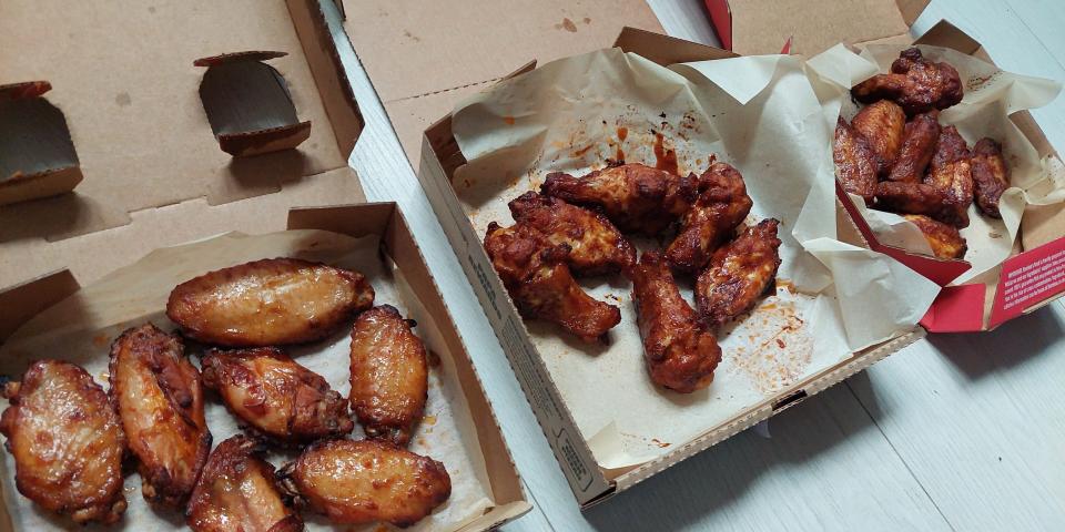Boxes of wings from Pizza Hut, Domino's, and Papa John's