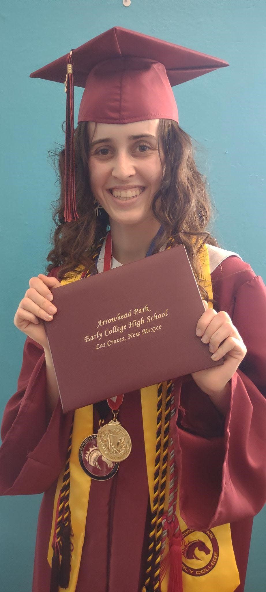 Arabella Camunez, a graduate of Arrowhead Park Early College High School, poses with her diploma in 2022.