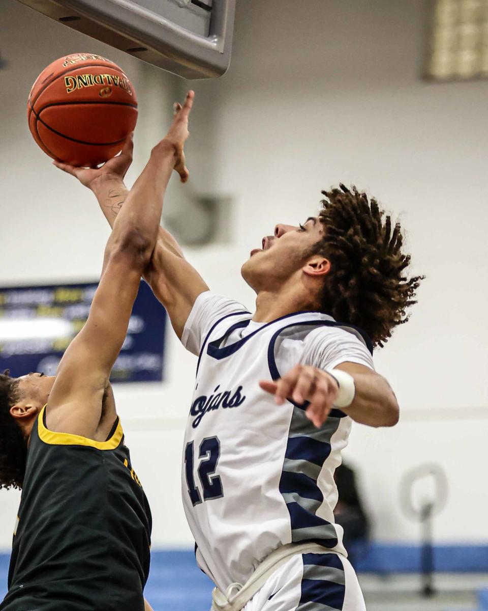 Jaitavius Kelly (12) attempts to score from behind the boards, but is fouled by Jalil Bethea (1). The Chambersburg Trojans played the Archbishop Wood Vikings in the PIAA Class 6A playoffs on Wednesday, March 15, 2023. The Vikings defeated the Trojans, 72-45.