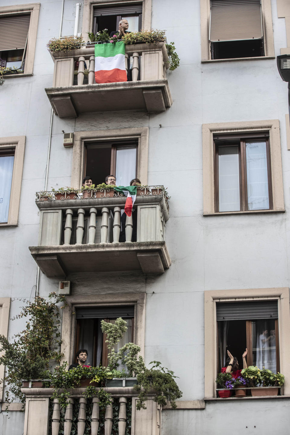 People applaud from balconies in front of the house of 23-year-old Italian volunteer Silvia Costanza Romano, in Milan, Italy, Sunday, May, 10, 2020. An Italian aid worker who was kidnapped in Kenya in late 2018 has been freed in Somalia. Italian Premier Giuseppe Conte on Saturday hailed the release of Silvia Romano, who was a 23-year-old volunteer with the humanitarian group Africa Milele when she was abducted in the coastal trading center of Chakama. (AP Photo/Luca Bruno)