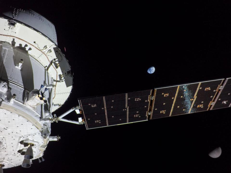 On flight day 13 of the Artemis I mission, NASA's Orion captured this view of Earth and the Moon on either sides of one of the spacecraft’s four solar arrays.