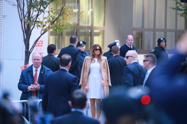 Melania Trump in a white dress with a camel coat casting her vote on election day. 