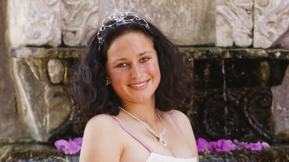 a woman in a pink dress holding a bouquet of flowers