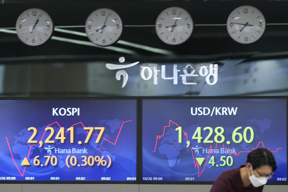 A currency trader works near screens showing the Korea Composite Stock Price Index (KOSPI), left, and the foreign exchange rate between the U.S. dollar and South Korean won at a foreign exchange dealing room in Seoul, South Korea, Wednesday, Oct. 26, 2022. Asian stock markets followed Wall Street higher on Wednesday as hopes rose that the Federal Reserve might ease off plans for interest rate hikes and Britain installed its third prime minister this year. (AP Photo/Lee Jin-man)