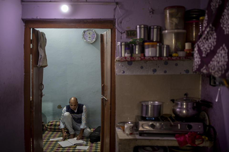 Muhammad Nasir Khan, who was shot by a Hindu mob during the February 2020 communal riots, sifts through his legal and medical files inside his home in North Ghonda, one of the worst riot affected neighborhood, in New Delhi, India, Friday, Feb. 19, 2021. As the first anniversary of bloody communal riots that convulsed the Indian capital approaches, Muslim victims are still shaken and struggling to make sense of their struggle to seek justice. (AP Photo/Altaf Qadri)