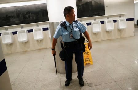 A police officer looks on as he chases after a flashmob protester inside Hong Kong International Airport, Hong Kong, China