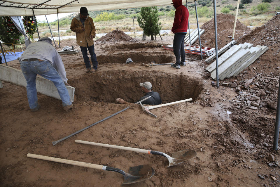 Men dig graves for Rhonita Miller, 30, and four of her young children Krystal and Howard, and twins Titus and Tiana, who were murdered by drug cartel gunmen, before their burial at a cemetery in LeBaron, Chihuahua state, Mexico, Friday, Nov. 8, 2019. A total of three women and six of their children, from the extended LeBaron family, were gunned down in a cartel ambush while traveling along Mexico's Chihuahua and Sonora state border on Monday. (AP Photo/Marco Ugarte)