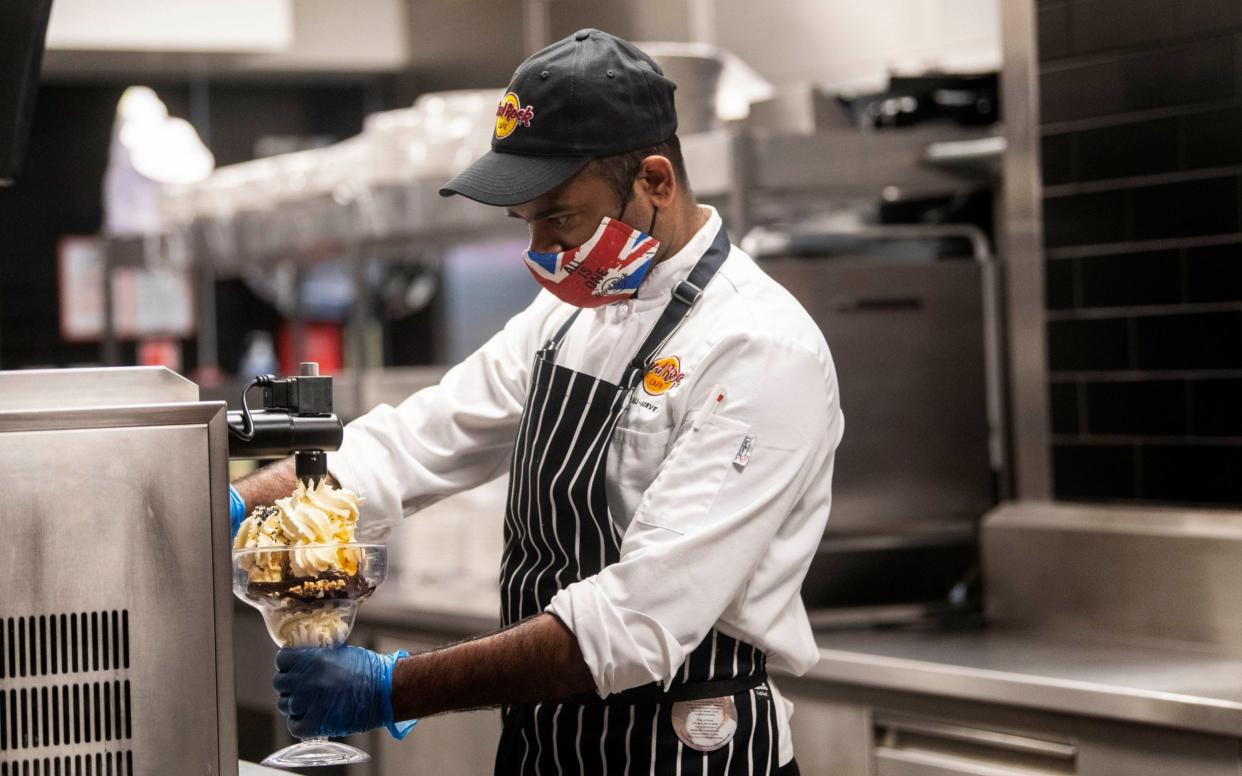 A chef wears PPE as he makes a chocolate brownie in the kitchen of the Hard Rock Cafe's European flagship restaurant in Piccadilly Circus, London - Victoria Jones/PA