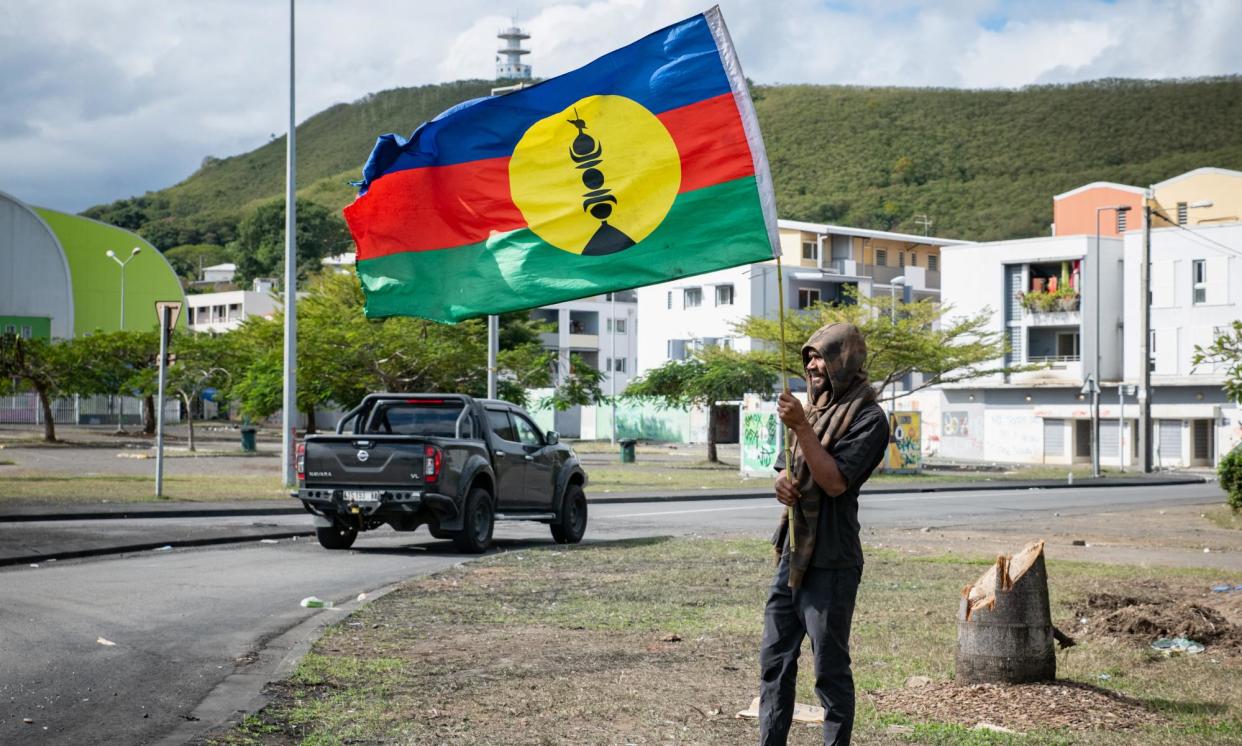 <span>A pro-independence supporter waves a flag on the side of a road ahead of French parliamentary elections in Nouméa, New Caledonia.</span><span>Photograph: Delphine Mayeur/AFP/Getty Images</span>