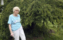 Tressie Corsi stands next to the cherry tree given to her by her husband outside of the house she has owned in Johnstown, Ohio, since 1972 that she is giving up to make way for an Intel manufacturing plant during an interview Monday, June 20, 2022. They raised four children and welcomed multiple generations of grandchildren and great-grandchildren, including some who lived right next door. (AP Photo/Paul Vernon)