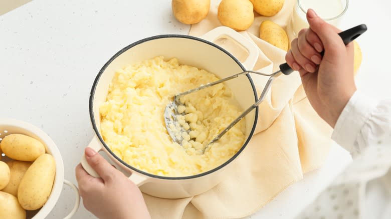 Person mashing potatoes