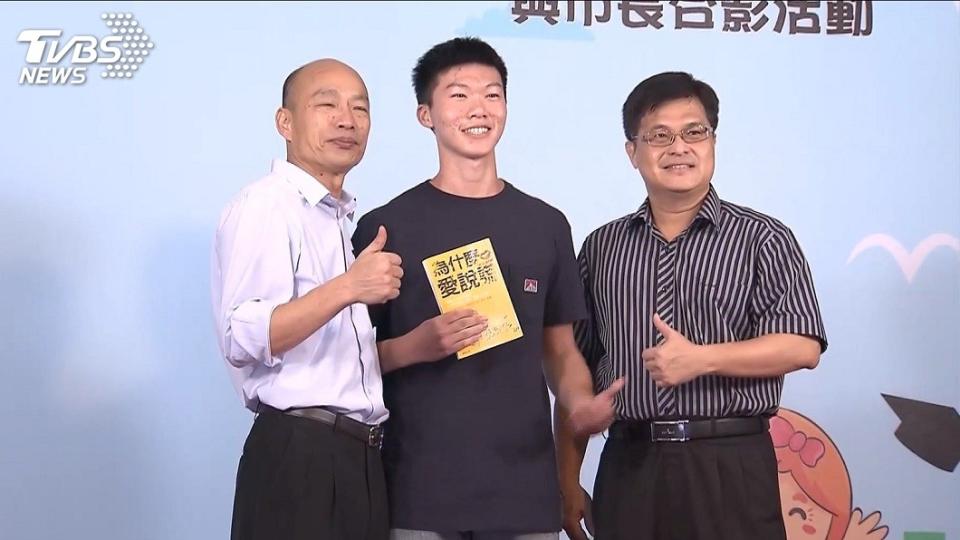 雄中一名學生和韓國瑜合影時，手中拿著一本書，引發外界聯想。(圖／TVBS)