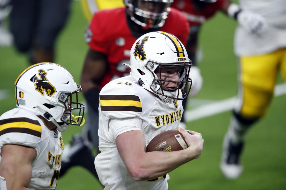 Wyoming quarterback Levi Williams (15) keeps the ball and makes a touchdown run against UNLV during the first half of an NCAA college football game in Las Vegas on Friday, Nov. 27, 2020. (Steve Marcus/Las Vegas Sun via AP)