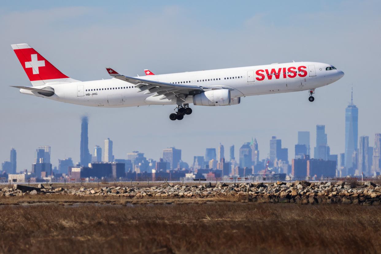 An Airbus A330 passenger aircraft of Swiss airlines arrives from Zurich at JFK International Airport in New York as the Manhattan skyline looms in the background on February 7, 2024.