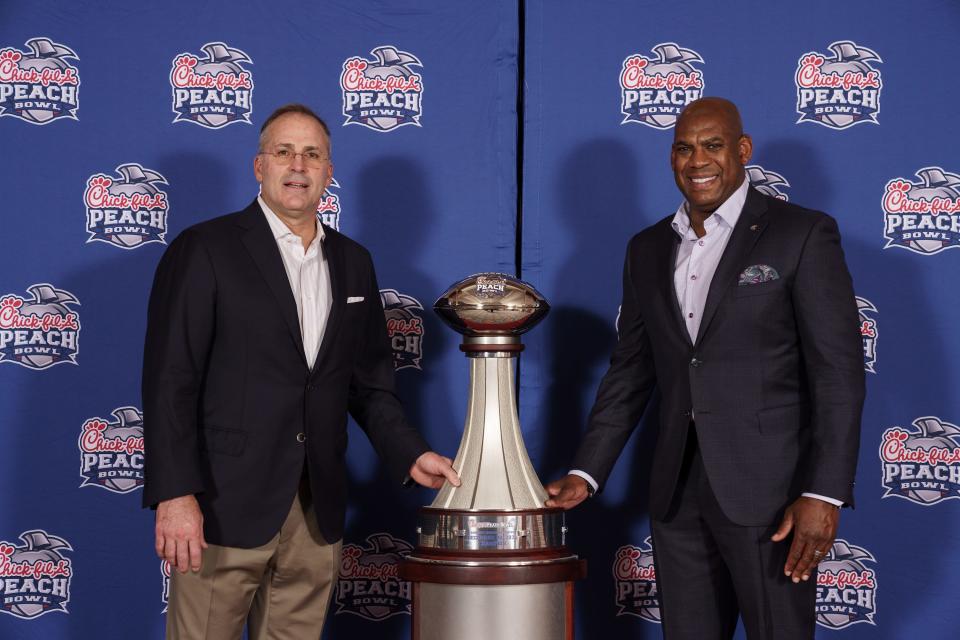Pitt head coach Pat Narduzzi and Michigan State head coach Mel Tucker pose for a photo with the Chick-fil-A Peach Bowl NCAA college football game trophy, Tuesday, Dec. 28, 2021, in Atlanta.