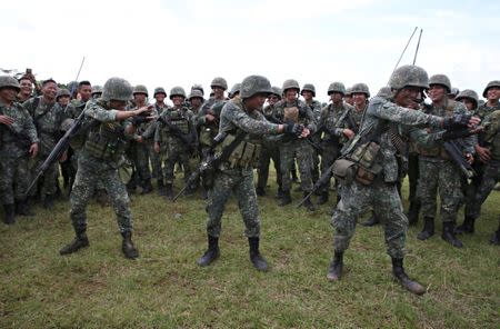 Members of the Philippine Marine Batallion Landing Team (MBLT) perform the "Baby Shark" dance to entertain their comrades during their send-off ceremony ending their combat duty against pro-Islamic State militant groups inside a military headquarters in Marawi city, southern Philippines October 21, 2017, a few days after President Rodrigo Duterte announced the liberation of Marawi city. REUTERS/Romeo Ranoco