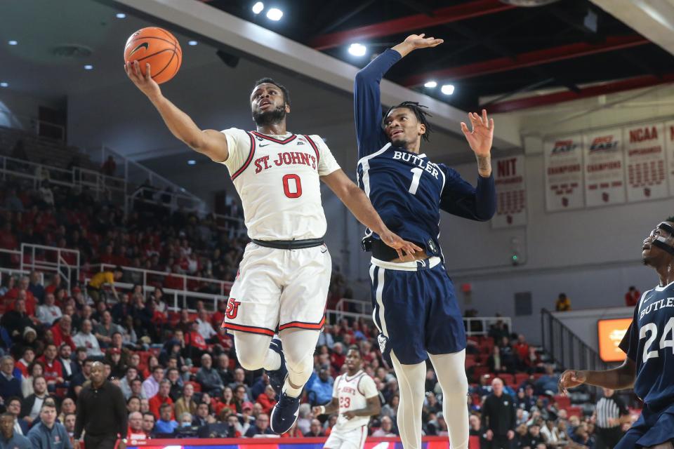 Jan 10, 2023; Queens, New York, USA;  St. John's Red Storm guard Posh Alexander (0) drives past Butler Bulldogs forward Jalen Thomas (1) for a layup in the second half at Carnesecca Arena. Mandatory Credit: Wendell Cruz-USA TODAY Sports