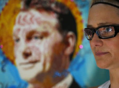 Hungarian artist Kriszta "Tereskova" Nagy poses next to her portrait of Prime Minister Viktor Orban in Budapest August 5, 2014. REUTERS/Laszlo Balogh