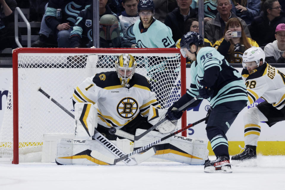 Seattle Kraken right wing Jesper Froden (38) shoots with Boston Bruins goaltender Jeremy Swayman (1) defending during the first period of an NHL hockey game Thursday, Feb. 23, 2023, in Seattle. (AP Photo/John Froschauer)