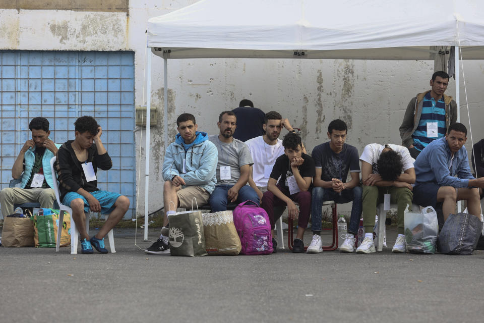 Survivors of a shipwreck wait to board a bus to transfer to Athens at the port of Kalamata, Greece, Friday, June 16, 2023. The round-the-clock effort continued off the coast of southern Greece despite little hope of finding survivors or bodies after none have been found since Wednesday, when 78 bodies were recovered and 104 people were rescued. (John Liakos/InTime News via AP)