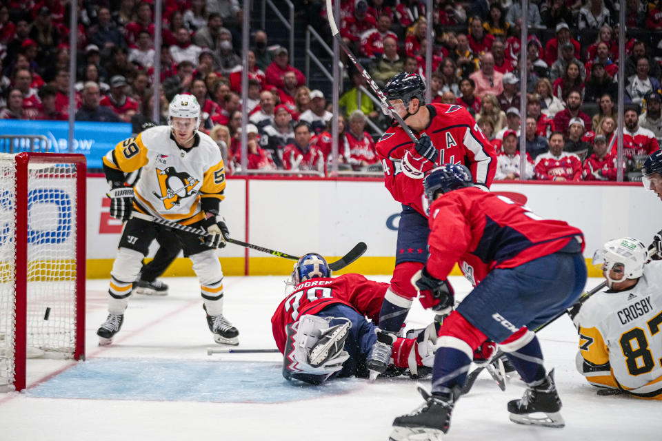 Pittsburgh Penguins center Sidney Crosby, right, scores in the second period of an opening night NHL hockey game against the Washington Capitals, Friday, Oct. 13, 2023, in Washington. (AP Photo/Andrew Harnik)