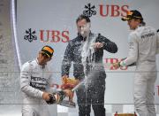 Mercedes driver Lewis Hamilton of Britain (L) celebrates beside second place teammate Nico Rosberg of Germany (R) on the podium after winning the Formula One Chinese Grand Prix in Shanghai on April 20, 2014