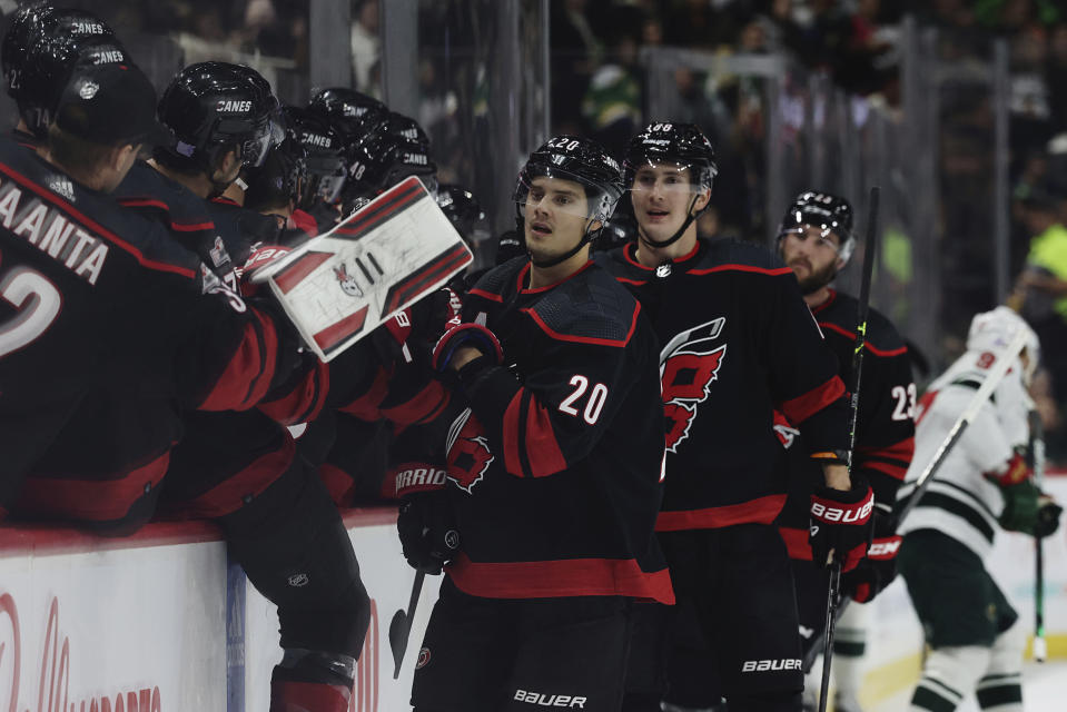 Carolina Hurricanes center Sebastian Aho (20) is congratulated by teammates for his goal against the Minnesota Wild during the first period of an NHL hockey game Saturday, Nov. 19, 2022, in St. Paul, Minn. (AP Photo/Stacy Bengs)