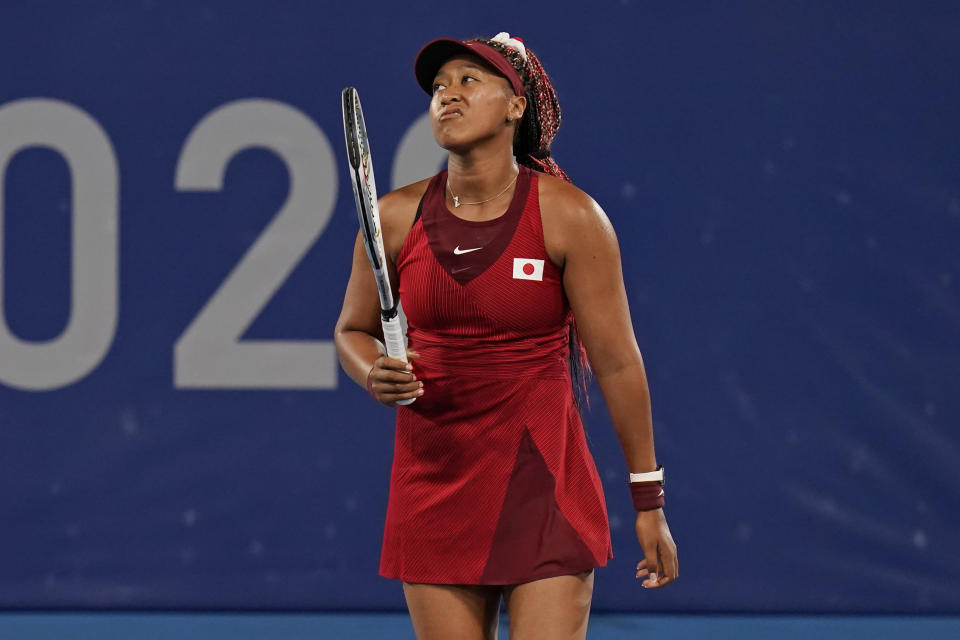 Naomi Osaka, of Japan, reacts after losing a point to Marketa Vondrousova, of the Czech Republic, during the third round of the tennis competition at the 2020 Summer Olympics, Tuesday, July 27, 2021, in Tokyo, Japan. (AP Photo/Seth Wenig)