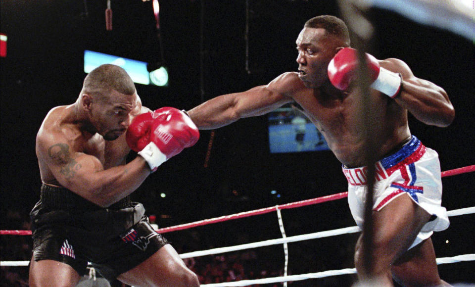 FILE - WBC heavyweight champion Mike Tyson, left, and WBA heavyweight champion Bruce Seldon exchange blows, Saturday, Sept. 7, 1996, in Las Vegas. In attendance that night were rapper Tupac Shakur, his associates, and their rivals watching Tyson knock out Seldon at the MGM Grand. After the match, Shakur, Marion "Suge" Knight and others started to brawl at the MGM hotel prior to heading to a night club where Shakur was shot multiple times while en route. (AP Photo/Jim Laurie, File)