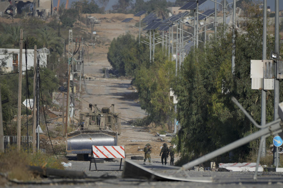 Israeli soldiers stand on Salah al-Din road in central Gaza Strip on Friday, Nov. 24, 2023, as the temporary ceasefire went into effect. (AP Photo/Hatem Moussa)