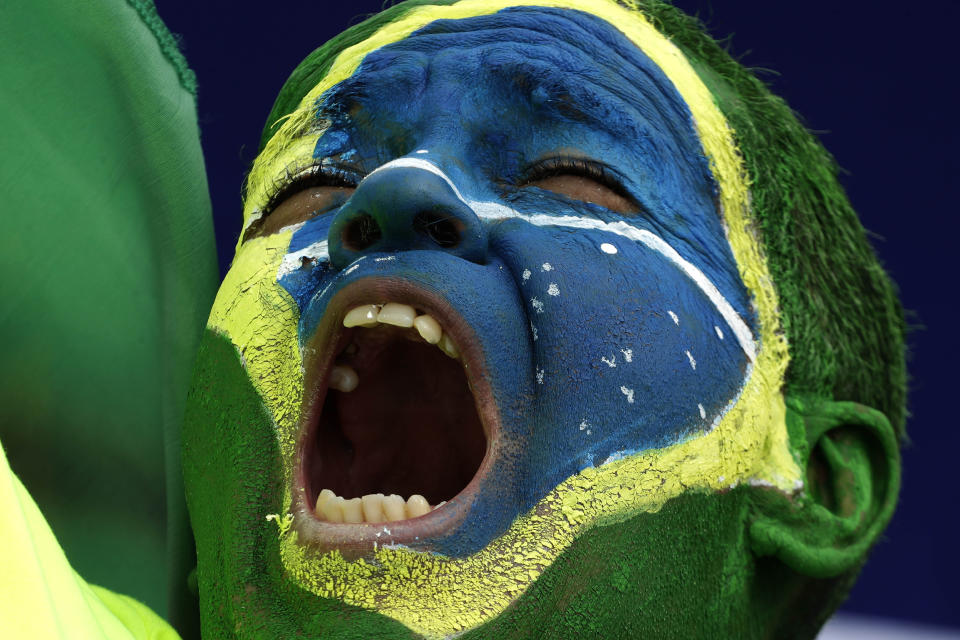 A demonstrator with the Brazilian flag painted on his face, shouts slogans during a caravan backing President Jair Bolsonaro’s anti-coronavirus-lockdown stance, marking May Day, or International Workers' Day, in Brasilia, Brazil, Saturday, May 1, 2021. (AP Photo/Eraldo Peres)