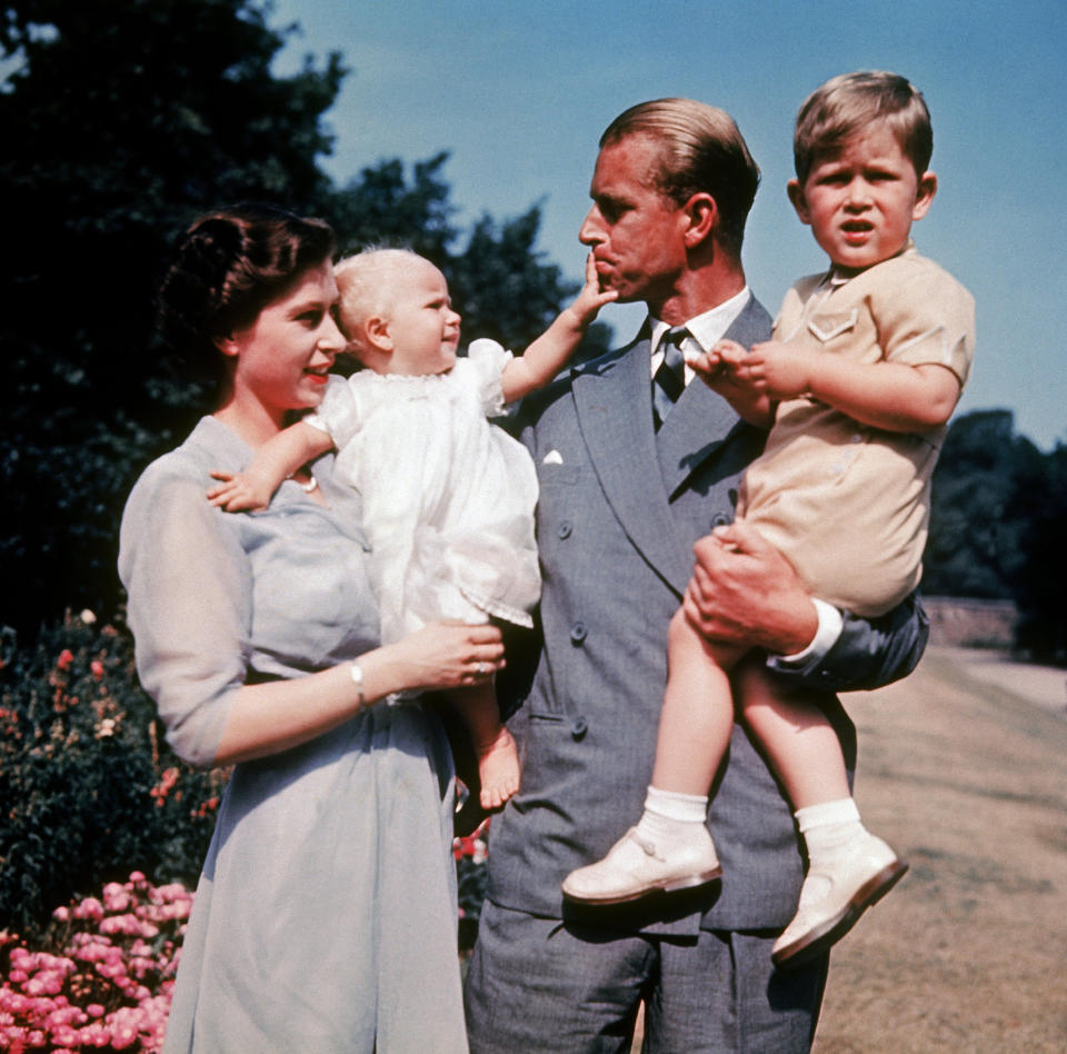 Former Princess Elizabeth holds her daughter, Princess Anne, who reaches out to her father, Prince Philip, as he holds Prince Charles in 1951. (Getty Images)