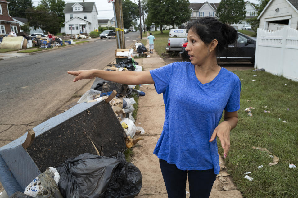 Flor Sosa stands near the home she shares with her sister in Manville, N.J., Sunday, Sept. 5, 2021, as she describes how the basement walls crumbled while they and others were in the house as the remnants of Hurricane Ida inundated the region. (AP Photo/Craig Ruttle)