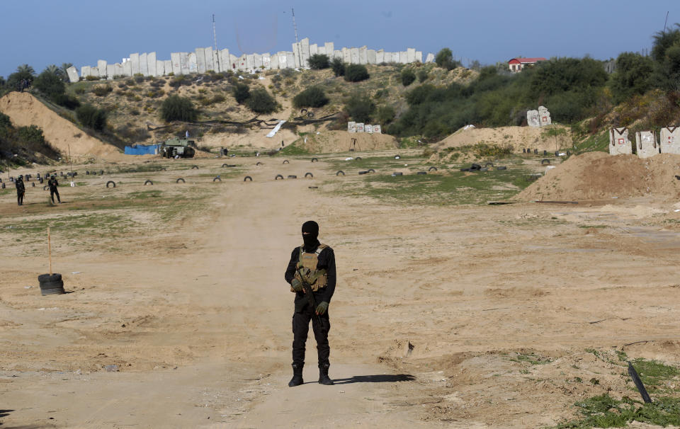 A Palestinian militant stands guard during a military drill organized by military factions outside Gaza City, Tuesday, Dec. 29, 2020. Palestinian militants in the Gaza Strip fired a salvo of rockets into the Mediterranean Sea on Tuesday as part of a self-styled military drill aimed at preparing for a possible war with Israel. (AP Photo/Adel Hana)