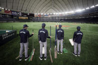 Staffs stand where spectators' stands are empty prior to a preseason baseball game between the Yomiuri Giants and the Yakult Swallows at Tokyo Dome in Tokyo Saturday, Feb. 29, 2020. Japan's professional baseball league said Thursday it will play its 72 remaining preseason games in empty stadiums because of the threat of the spreading coronavirus.(AP Photo/Eugene Hoshiko)