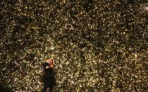 A woman takes a picture of herself with part of the Christmas illumination of the main shopping mall Kurfuerstendamm boulevard in Berlin, December 1, 2013. REUTERS/Fabrizio Bensch (GERMANY - Tags: SOCIETY)