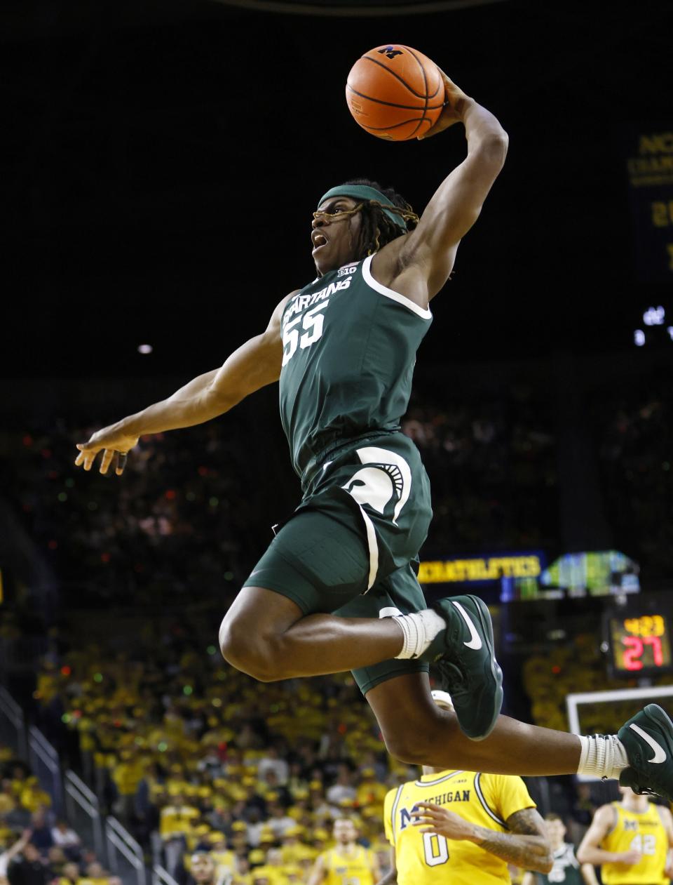 Michigan State forward Coen Carr (55) goes up to dunk against the Michigan during the first half of an NCAA college basketball game Saturday, Feb. 17, 2024, in Ann Arbor, Mich. (AP Photo/Duane Burleson)