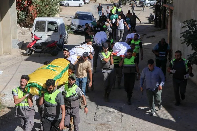 Dolientes portan los cuerpos de los miembros de una misma familia que murieron durante un ataque aéreo israelí dirigido contra la localidad de Jbal el-Botm, en el sur de Líbano, antes de su funeral, el 26 de septiembre de 2024. 