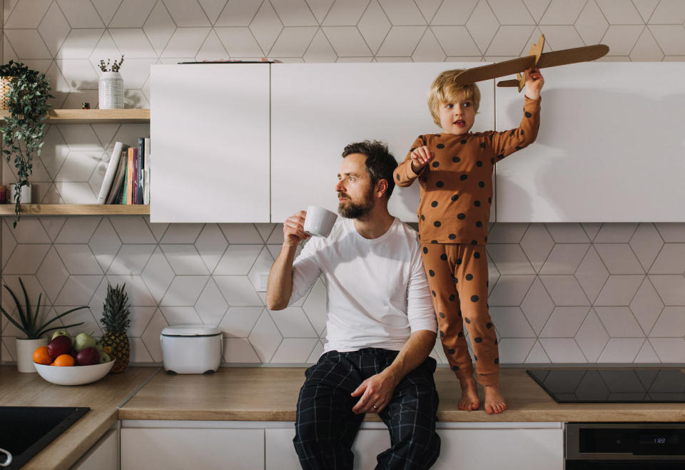 Father sitting on kitchen counter with his little son and having morning coffee. (Halfpoint Images / Getty Images)