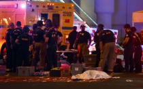 <p>A body lies under a sheet as fire and rescue personnel gather at the intersection of Las Vegas Boulevard and Tropicana Ave. after a mass shooting at a country music festival nearby on Oct. 1, 2017 in Las Vegas, Nevada. (Photo: Ethan Miller/Getty Images) </p>