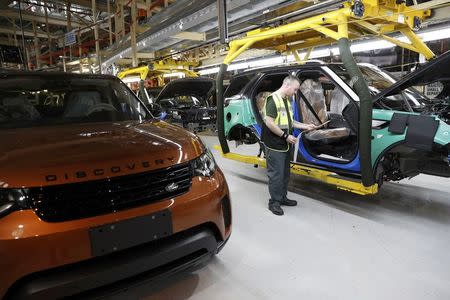 Worker George Baker looks at a build card for a vehicle destined for China at the Jaguar Land Rover facility in Solihull, Britain, January 30, 2017. REUTERS/Darren Staples