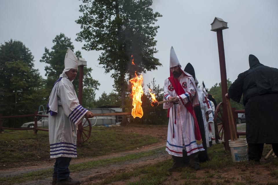 El fuego tiene un papel fundamental en los actos del KKK. Un capellán ("Imperial Kludd") del grupo Rebel Brigade Knights enciende una antorcha a otro miembro del KKK ("Klansman") del capítulo Nordic Order Knights, durante una fiesta privada en Henry County, Virginia. <br><br>Crédito: REUTERS/Johnny Milano