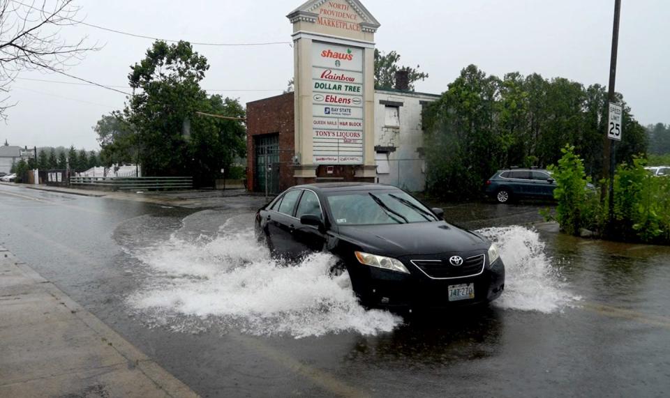 A car navigates the flooded section of Douglas Ave in front of the North Providence Marketplace on Monday after a downpour flooded the area.