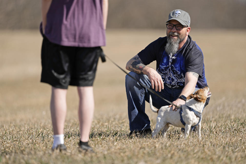 Dusty Farr talks with his transgender daughter at a park near Smithville, Mo., Sunday, Feb. 25, 2024. Farr is suing the Platt County School District after his daughter was suspended for using the girl's bathroom at the Missouri high school she attended. (AP Photo/Charlie Riedel)
