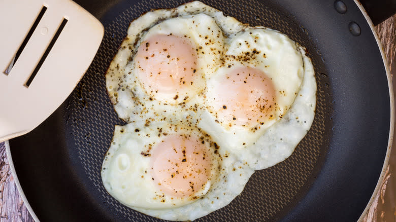 Three eggs frying in a pan