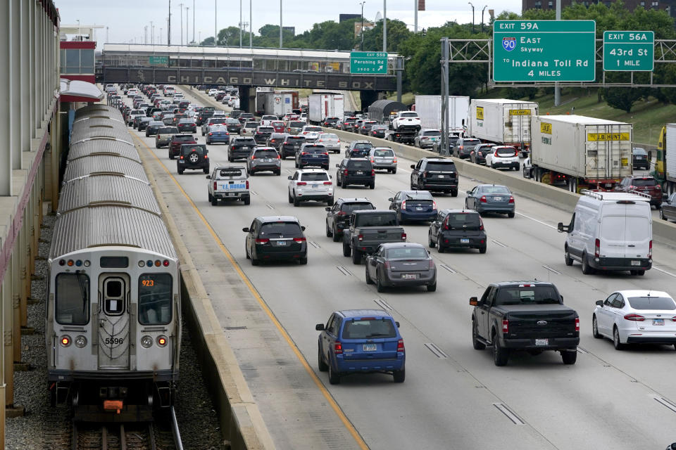 Motorists head southbound in the local and express lanes on Interstates 90-94 in slow and thickening traffic as a CTA train enters a station on the first day of the Fourth of July holiday weekend Friday, July 1, 2022, in Chicago. (AP Photo/Charles Rex Arbogast)