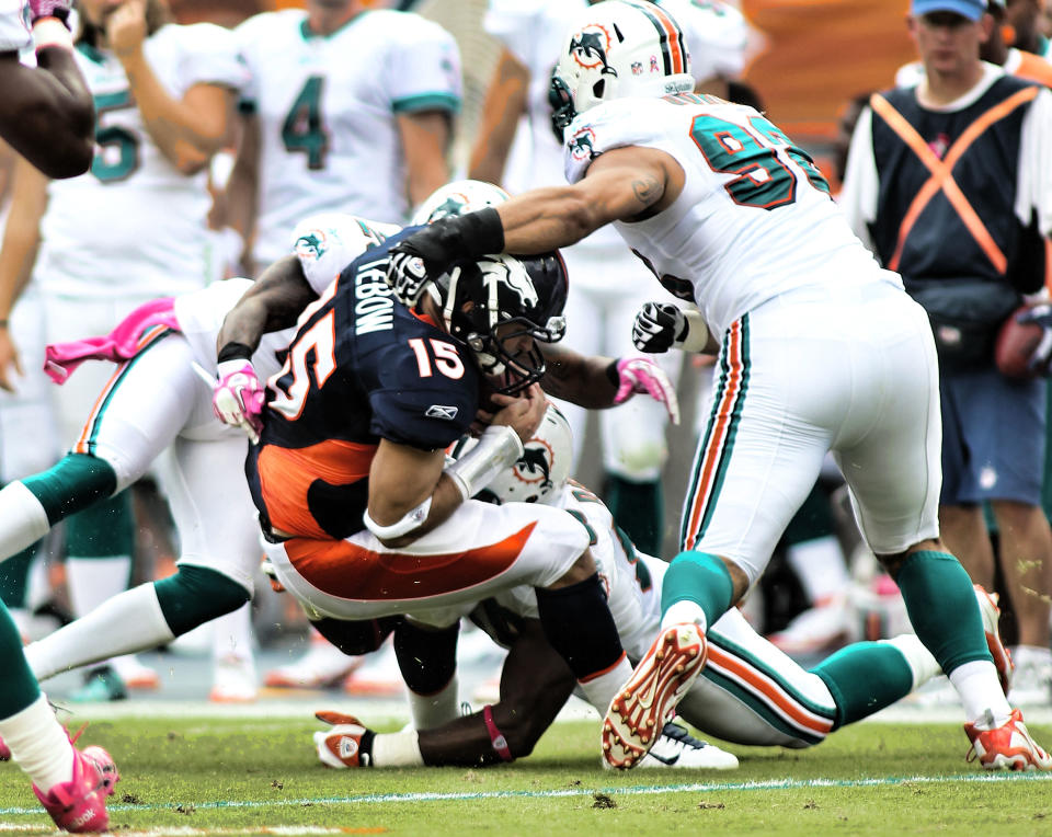 MIAMI GARDENS, FL - OCTOBER 23: Quarterback Tim Teebow #15 of the Denver Broncos is sacked by Linebacker Jared Odrick #98 the Miami Dolphins at Sun Life Stadium on October 23, 2011 in Miami Gardens, Florida. (Photo by Marc Serota/Getty Images)