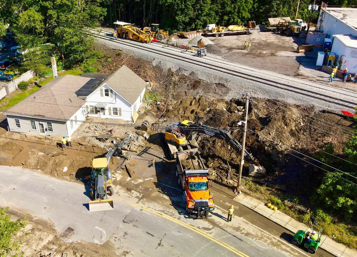 This aerial photo shows repaired railroad tracks to the west of the North Leominster train station. The cleanup on Hamilton Street continues. At top of photo is the rear of the Route 13 shopping plaza that includes Wyman's Liquors.