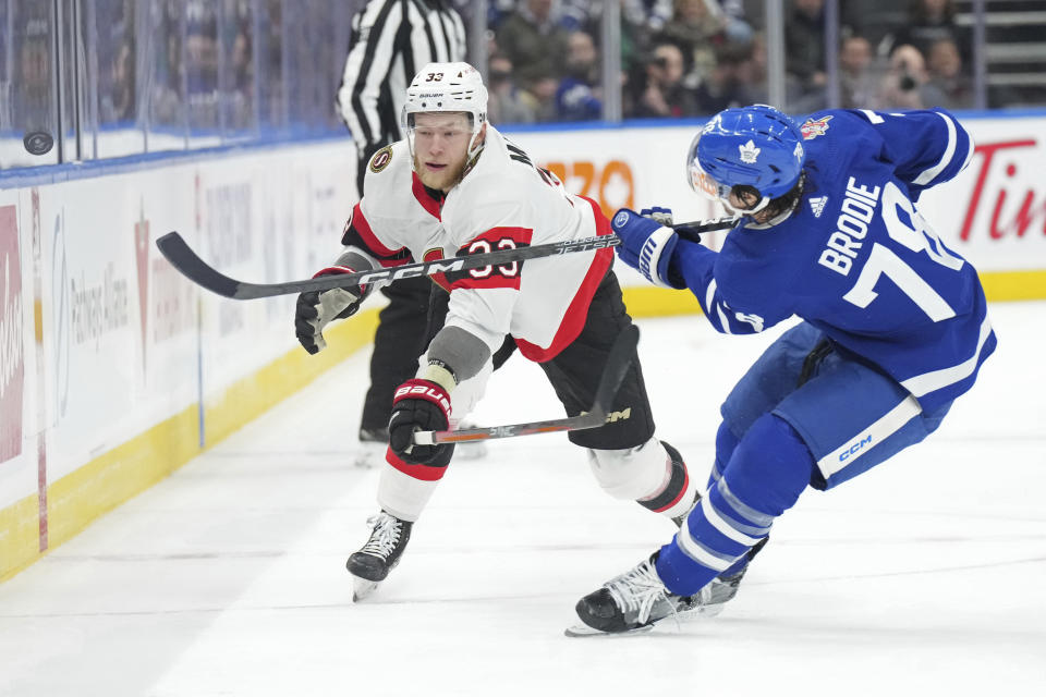 Toronto Maple Leafs' TJ Brodie clears the puck from Ottawa Senators' Nikolas Matinpalo during the first period of an NHL hockey game in Toronto, on Wednesday, Nov. 8, 2023. (Chris Young/The Canadian Press via AP)